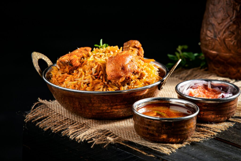 Top 10 Biryani Styles in India You Must Try Once in Life Admin | July 11, 2025 | 10 Min Read “Ek plate Biryani aur duniya side mein” – agar aap bhi iss thought se relate karte ho, toh bhai/sis you’re a certified Biryani lover! India mein biryani sirf ek dish nahi hai, yeh ek emotion hai. Har state ka apna alag style, alag swag aur ek dum different flavour hota hai. Kuch jagah pe dum wala magic hota hai, toh kahin saffron aur dry fruits ka royal touch. Is blog mein hum leke aaye hain India ke top 10 most famous biryanis – from the streets of Hyderabad to the alleys of Lucknow. Ready ho jao ek flavourful journey ke liye! ⭐ 1. Hyderabadi Biryani – Full Dum, Full Swag Location: Hyderabad, Telangana Yeh biryani ek dum king hai! Dum-style cooking mein meat ko kaccha chawal ke saath slow cook kiya jata hai. Masala thoda spicy hota hai, but perfectly balanced. Special touch: Fried onions, mint, saffron Tangy taste from lemon or yogurt Chicken or mutton – both hit hai! Best combo: Mirchi ka salan + raita Hyderabad aaye aur yeh biryani nahi khai toh kya khaak travel kiya! ⭐ 2. Lucknowi (Awadhi) Biryani – Nawabon Wali Biryani Location: Lucknow, Uttar Pradesh Is biryani ka style thoda classy hai. Rice aur meat separately cook hote hain aur fir dum lagta hai – flavour milta hai lekin masala overload nahi hota. Highlights: Light & aromatic Kewra water for fragrance Long-grain basmati rice Best with: Burhani raita + mint chutney Nawabi taste ke saath elegance chahiye? This one’s for you. ⭐ 3. Kolkata Biryani – Aloo Ka Tadka Location: Kolkata, West Bengal Sabse unique part? Aloo (potato) in biryani! Taste thoda mild aur sweet hota hai, lekin aloo ki wajah se full paisa vasool. Why it stands out: Subtle flavours Potato + boiled egg Ghee ka halka touch Goes best with: Plain curd ya baingan ka chokha Jo log biryani mein aloo se pyaar karte hain, yeh unka heaven hai! ⭐ 4. Malabar Biryani – South Ka Coastal Hero Location: Kerala Ye biryani short grain rice (jeerakasala) se banti hai aur coconut oil ka slight flavour hota hai. Chicken or mutton dono hi popular hain. Flavour notes: Slight sweetness (raisins + onions) Ghee-based richness Not too spicy Pair with: Coconut chutney + raita Beach vibe aur Malabar biryani – kya combo hai bhai! ⭐ 5. Ambur Biryani – Tamil Nadu Ki Street Star Location: Ambur, TN Highways aur dhabe ka legend – Ambur biryani! Red chili based spicy masala aur curd se marinated meat ka combo. What's special: Short-grain rice Smoky, spicy flavour Slightly oily but addictive Eat with: Kathirikai (eggplant curry) Isko khake tongue dance karta hai – full spicy feel. ⭐ 6. Dindigul Biryani – Pepper Punch Wali Location: Dindigul, Tamil Nadu Zyada red chili nahi, lekin black pepper ka punch hota hai. Aur curd + lemon ka tangy twist bhi milta hai. Highlights: Seeraga samba rice Chunky mutton pieces Tangy-spicy combo Perfect with: Onion raita Yeh biryani thodi hatke hai, try zarur karna. ⭐ 7. Sindhi Biryani – Chatpati & Bold Location: Mumbai & Sindh Ismein hota hai spice ka dhamaka! Dried plums, green chilies, yogurt, aur tomatoes se banta hai iska chatpata flavour. Kya alag hai: Sour + spicy taste Deep red masala Bold aroma Pair with: Boondi raita + salad Yeh biryani sirf taste nahi, ek zabardast experience hai. ⭐ 8. Bohri Biryani – Sweet-Spicy Delight Location: Mumbai (Bohri Mohalla) Sweet aur spicy flavours ka combo. Caramelised onions, dry fruits aur slow-cooked meat isko classy banata hai. Key points: Balanced flavour Soft rice texture Bohri-style serving in thaal Best with: Pineapple raita or imli chutney Yeh biryani taste ke saath presentation ka bhi king hai. ⭐ 9. Mughlai Biryani – Dilli Ka Royal Swad Location: Old Delhi Isme hoti hai richness – dry fruits, saffron, ghee, aur perfectly cooked meat. Features: Aromatic & royal Cashews, raisins Mildly spiced but flavourful Goes with: Mint raita + shami kebab Dilli wale isko sirf khana nahi, celebrate karte hain. ⭐ 10. Jaipuri Biryani – Rajasthani Twist Wali Location: Jaipur, Rajasthan Jaipuri biryani mein thoda spice hota hai Rajasthani style ka, aur sometimes paneer/dry fruits bhi add karte hain. Khaas points: Ghee + saffron Strong spices Dry fruit & mint combo Enjoy with: Chaach + lehsun chutney Isme thoda tandoori, thoda royal, thoda desi – sab kuch hai! 🍲 Bonus: Veg Biryani Lovers, Don’t Worry 😅 Yes, some people do love veg biryani. Technically pulao hota hai, but agar masala proper ho toh biryani wali feel aa hi jaati hai. Bangalore aur Gujarat side mein kaafi popular hai. 📌 Conclusion: Biryani Ek Nasha Hai ❤️ India mein biryani har gali, har city, har culture ka flavor carry karti hai. From royal Nawabi biryani to spicy Ambur wali – taste sabka apna alag hai, lekin pyaar ek jaisa. So, agar aap real foodie ho, toh ye 10 types try karna life ke checklist mein likh lo! Aapki favourite biryani kaunsi hai? Comment mein batao! Aur agar aur blogs chahiye street food, chaats, or thali pe — toh bhai bolo, next post ready ho jayega.
